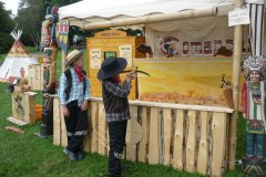 Zwei Jungs am Stand bei Pfeil und Bogen schießen